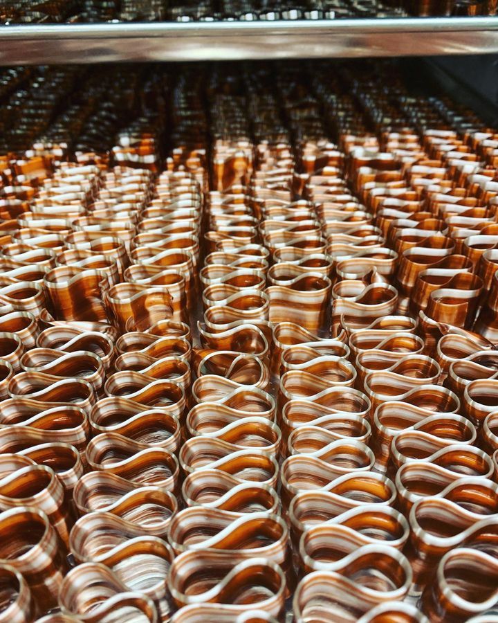 A bunch of copper pipes are lined up on a shelf.