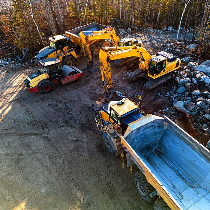 overhead view of various heavy equipment on a job site in a forest