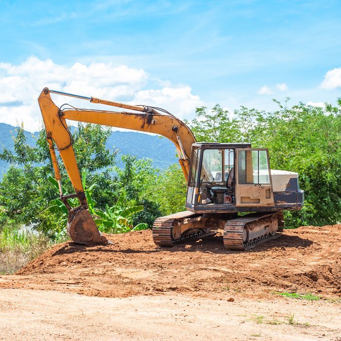 excavator digging against a hilly backdrop