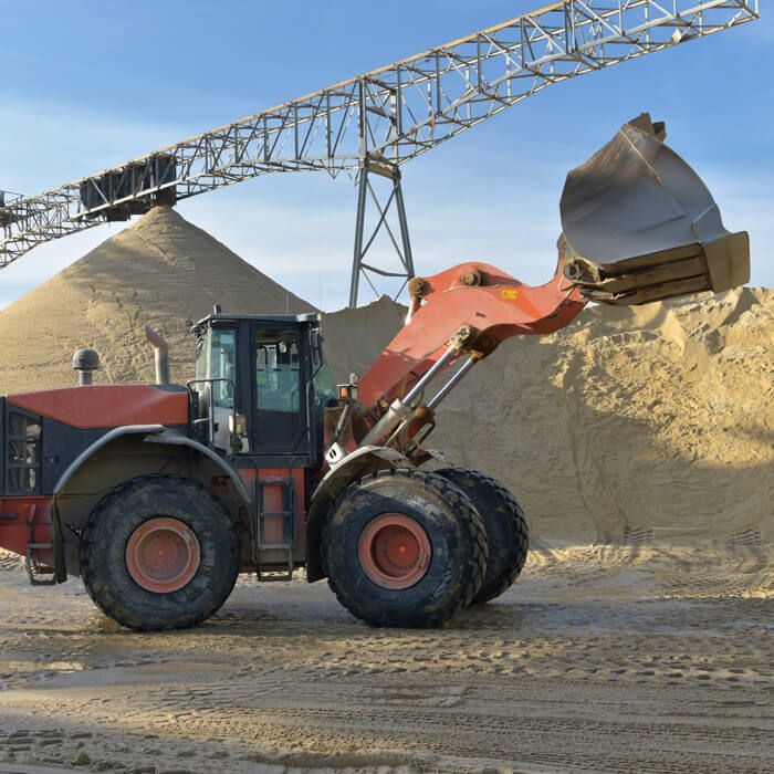 wheel loader loading gravel onto a truck