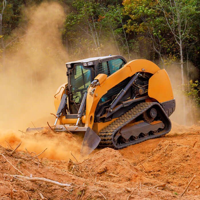 skid steer in the process of clearing land