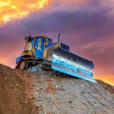 dozer on top of a hill at sunset