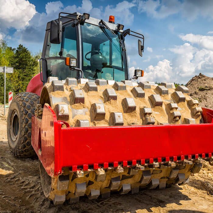 red pad foot roller on a job site