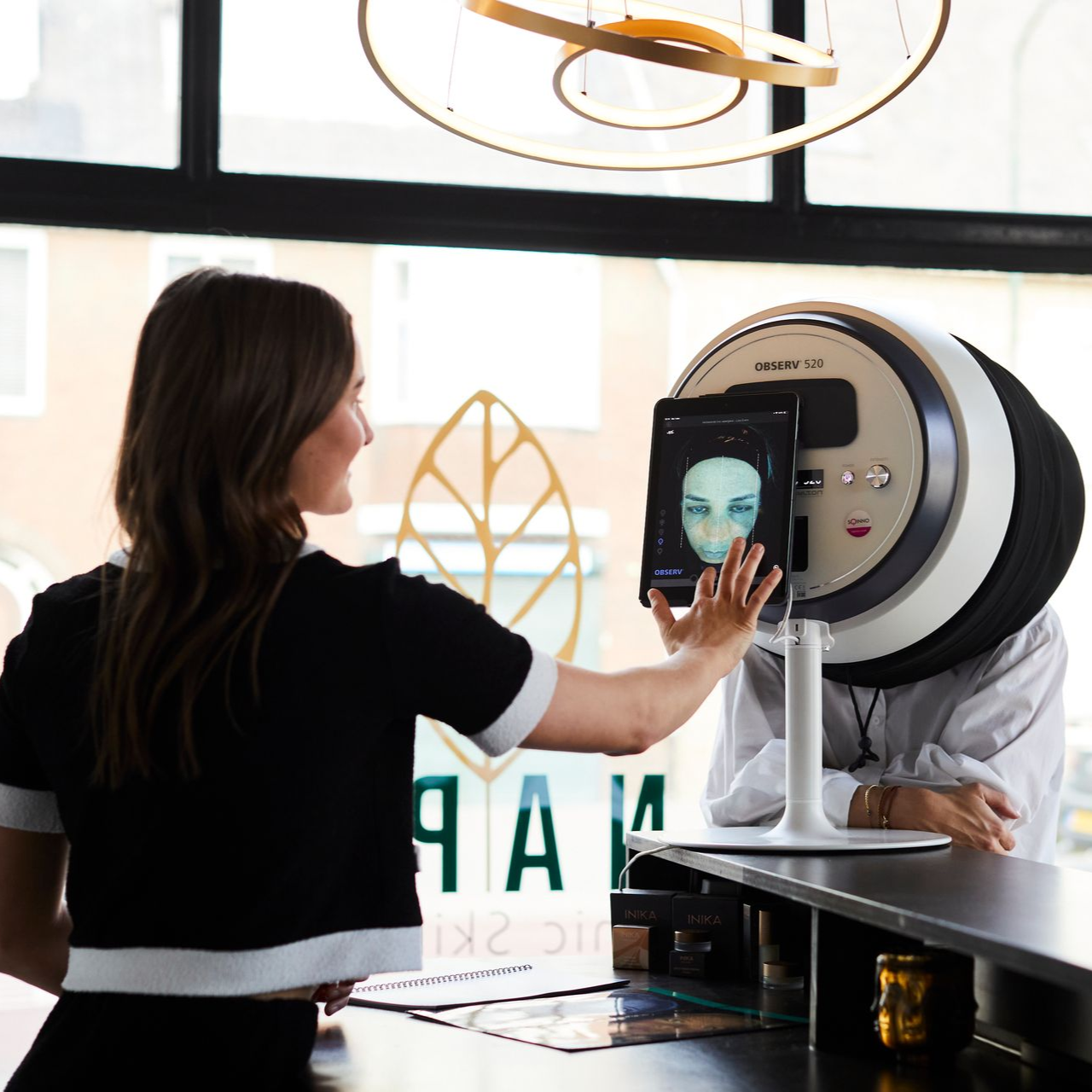 Vrouw maakt gebruik van een gezichtsscanner in een lichte, moderne ruimte.