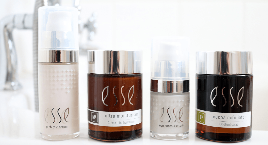 Vier cosmetische potjes en flesjes met het opschrift 