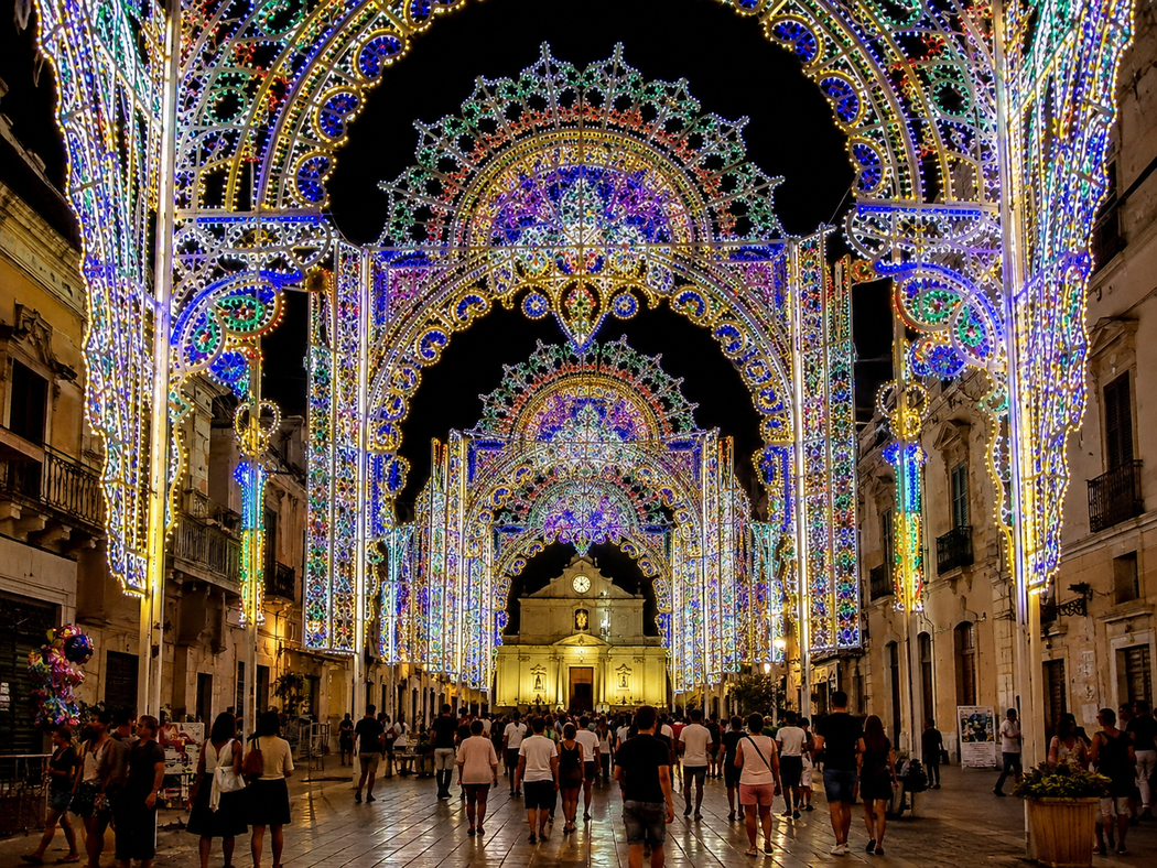 La navata gremita della cattedrale, illuminata da colorati archi di luci natalizie, con un altare illuminato in fondo, è gremita.