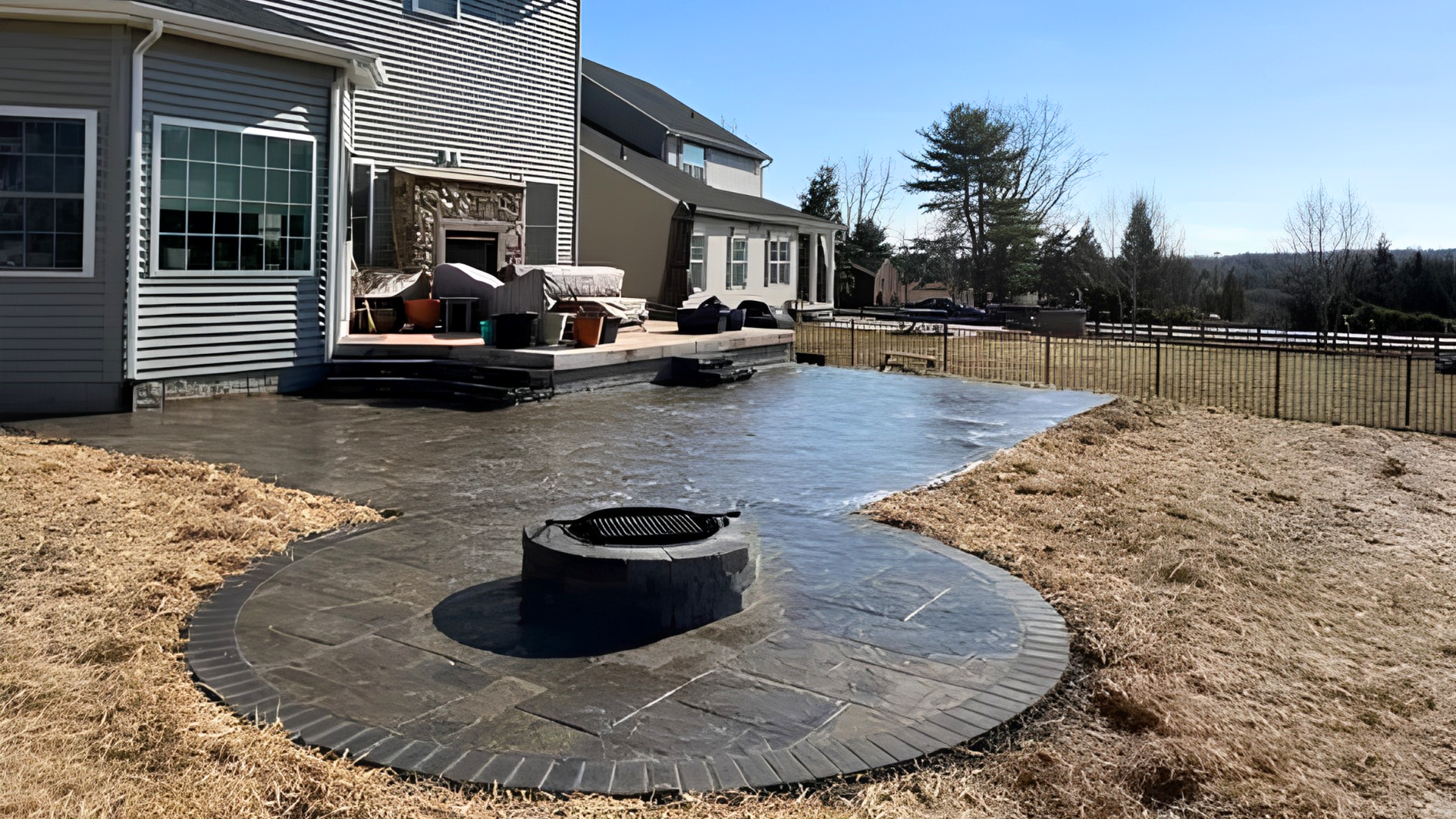 Round stamped concrete fire pit patio with stone veneer built-in fire feature in a Frederick County,