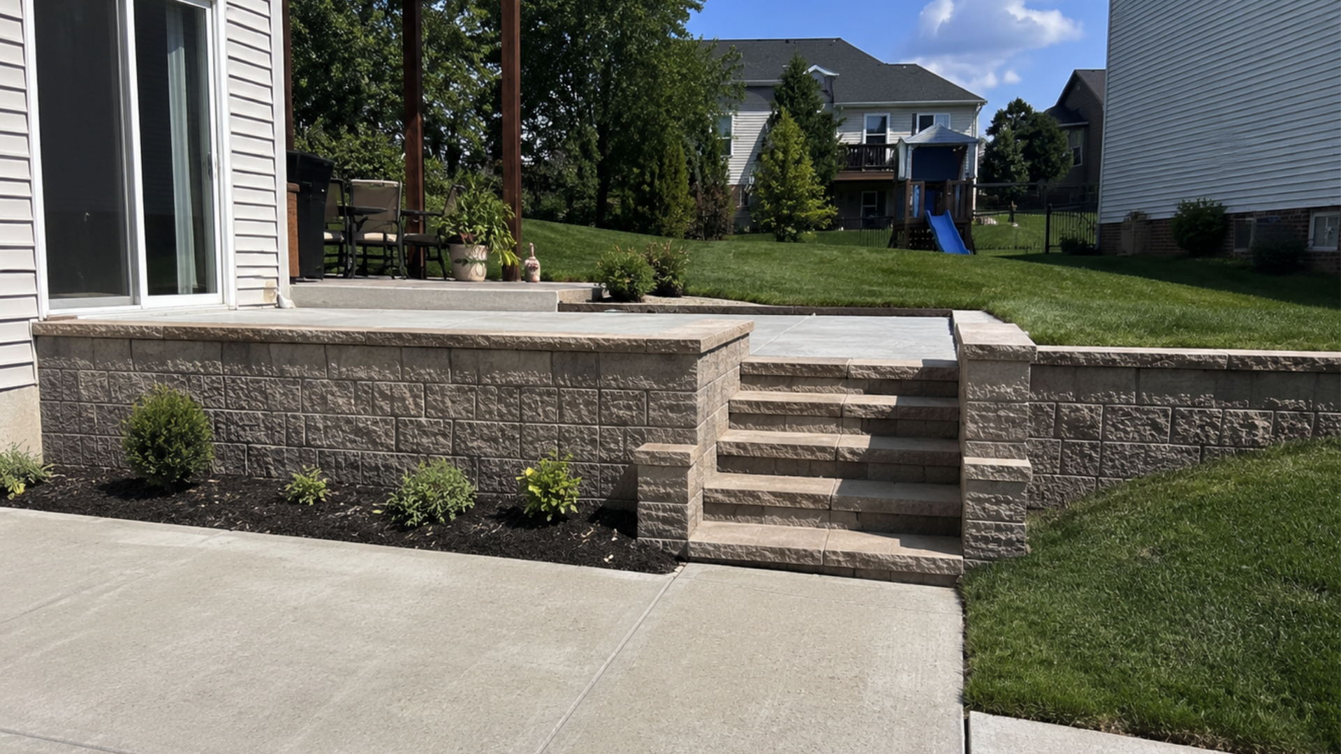 Concrete retaining wall with steps connecting different yard levels on a Frederick County property