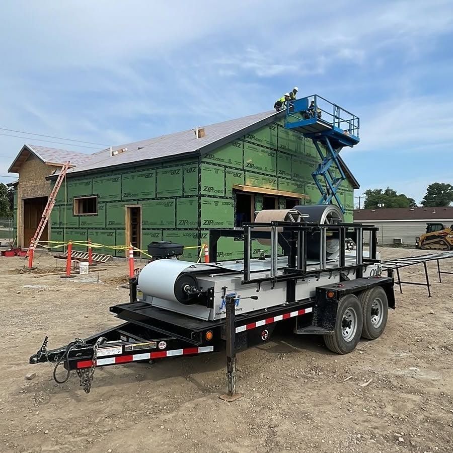 Construction trailer with equipment parked outside a green house under renovation