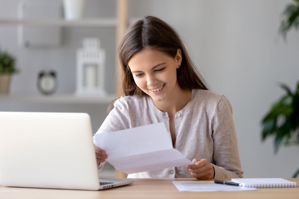 Lady Reading a Letter and Smiling — Northern Accounting Solutions In Brisbane, QLD
