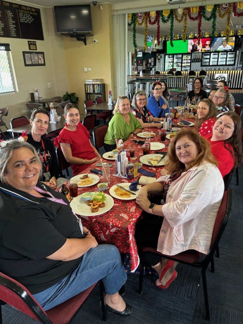 A Group of People At A Table Eating Looking At The Camera With FOod In Front Of Them — Maryborough Cricket Club In Maryborough, QLD