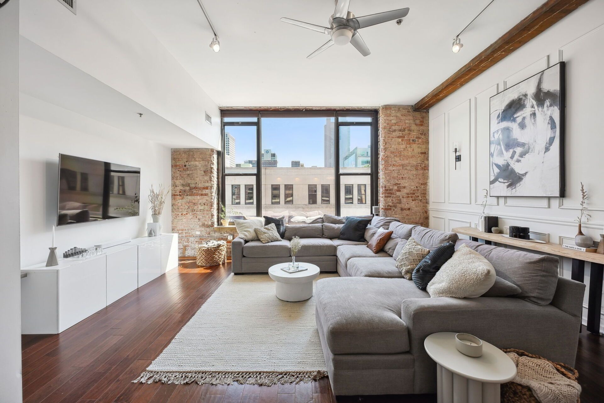 A living room with a large sectional couch and a flat screen tv