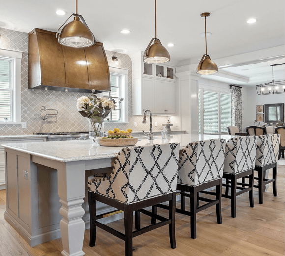 A kitchen with a large island and lots of chairs