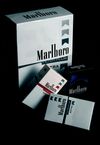 Various packs of Marlboro cigarettes, mostly white with the brand logo and color-coded filters, in a dark setting.