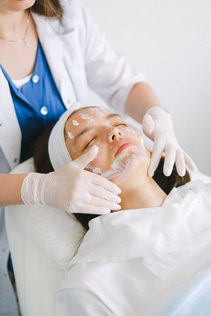 Person receiving facial treatment from a person wearing gloves.