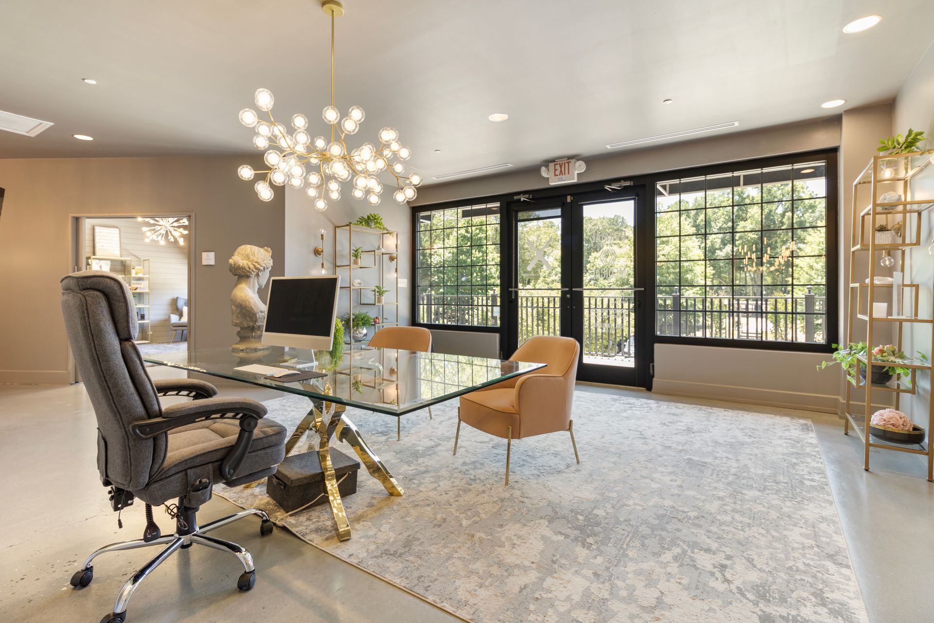 A home office with a desk and chairs and a large window.