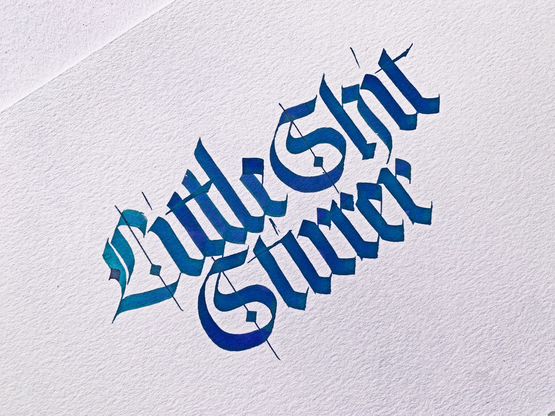 Gothic-style blue calligraphy on white paper reads 