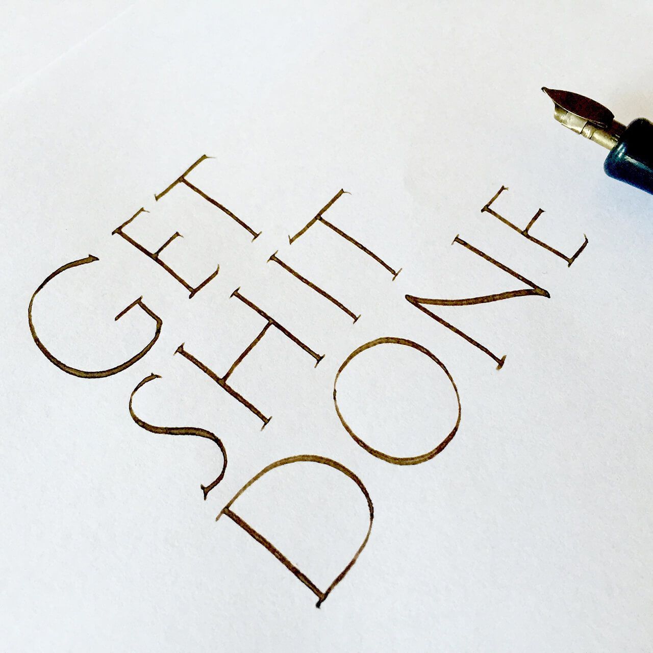 Handwritten calligraphy in brown ink on white paper reads, 