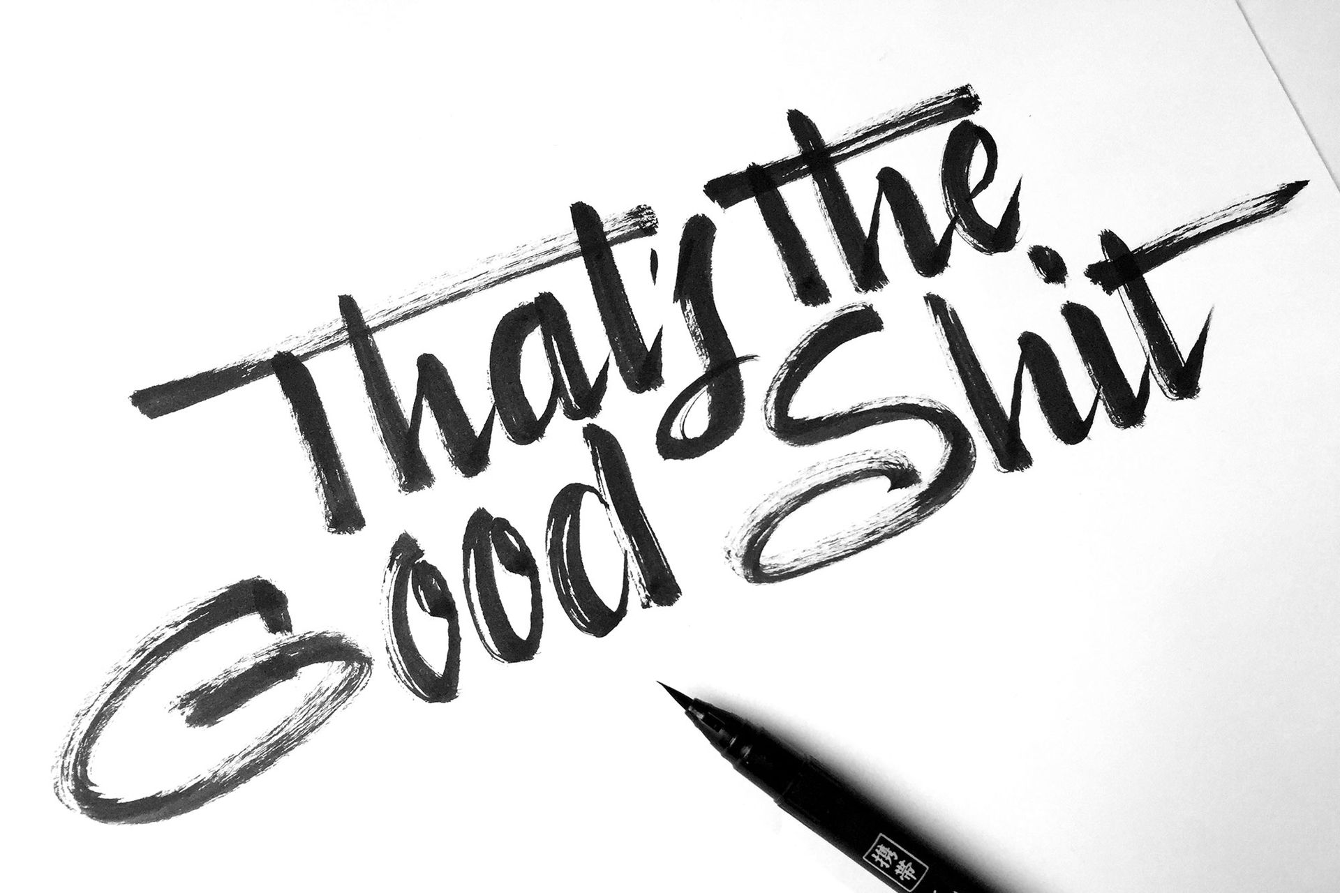 A black marker sits below the hand-lettered calligraphy on white paper that reads,