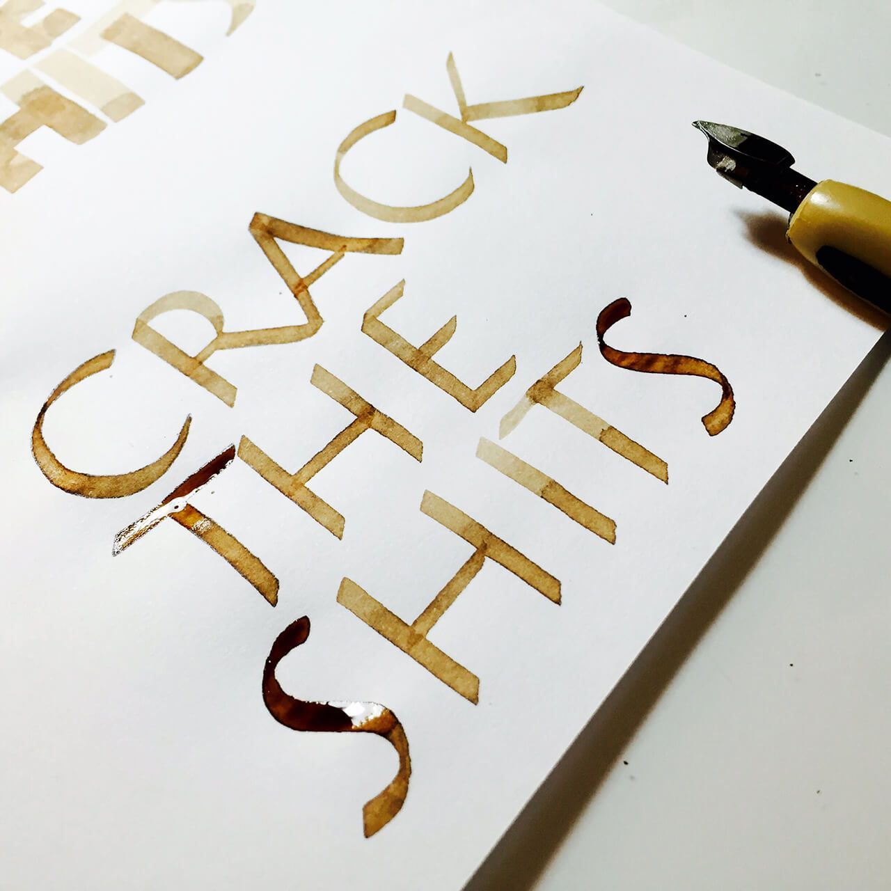 Calligraphy written in brown ink on white paper reads