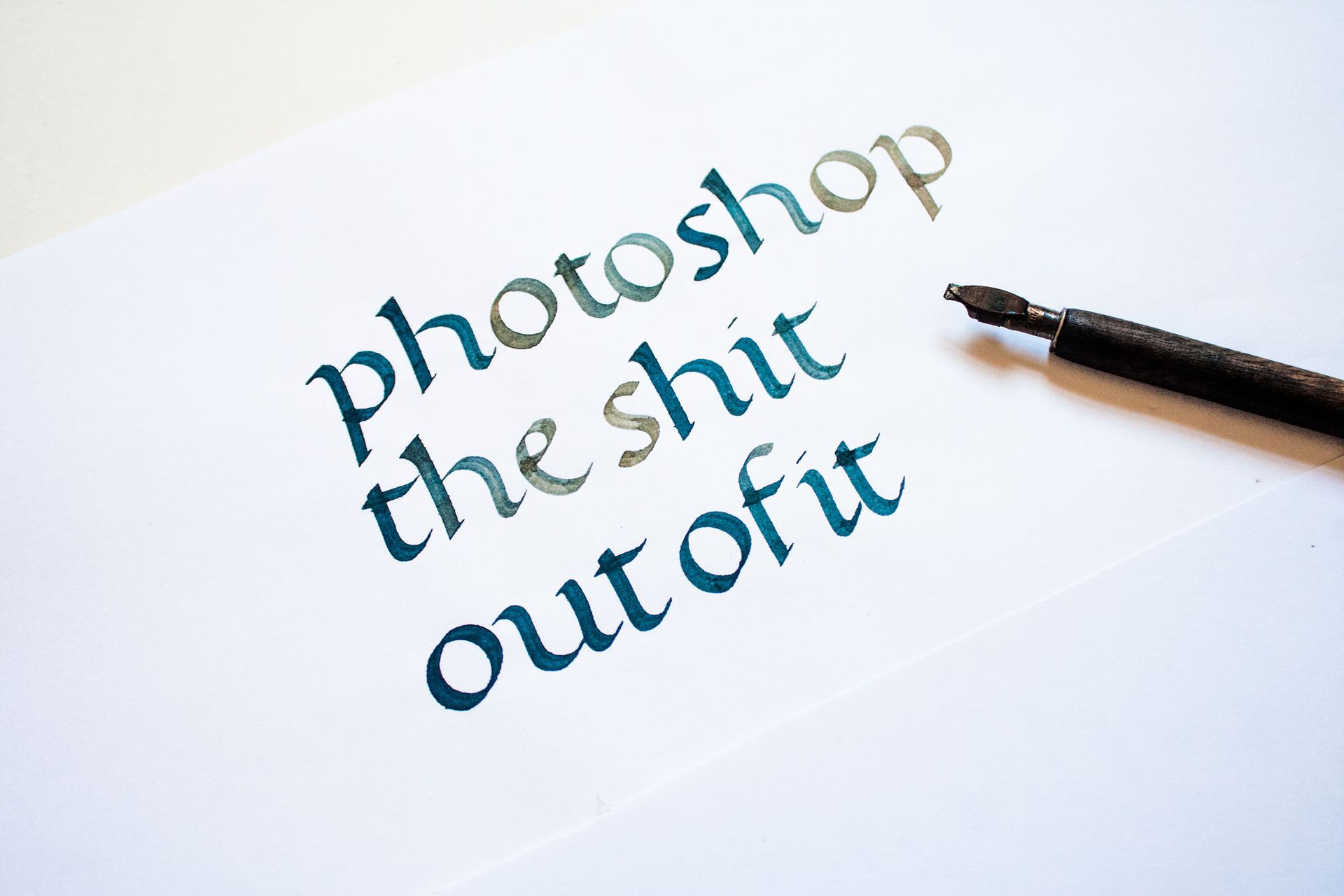 Artistic calligraphy on white paper featuring the centered, scripted word