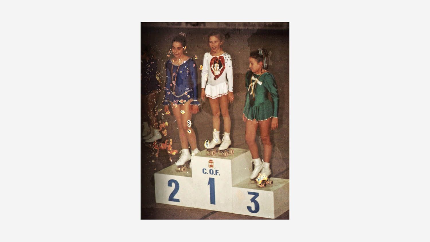 Three athletes standing on a winners’ podium with medals, numbers 1, 2, and 3 visible.