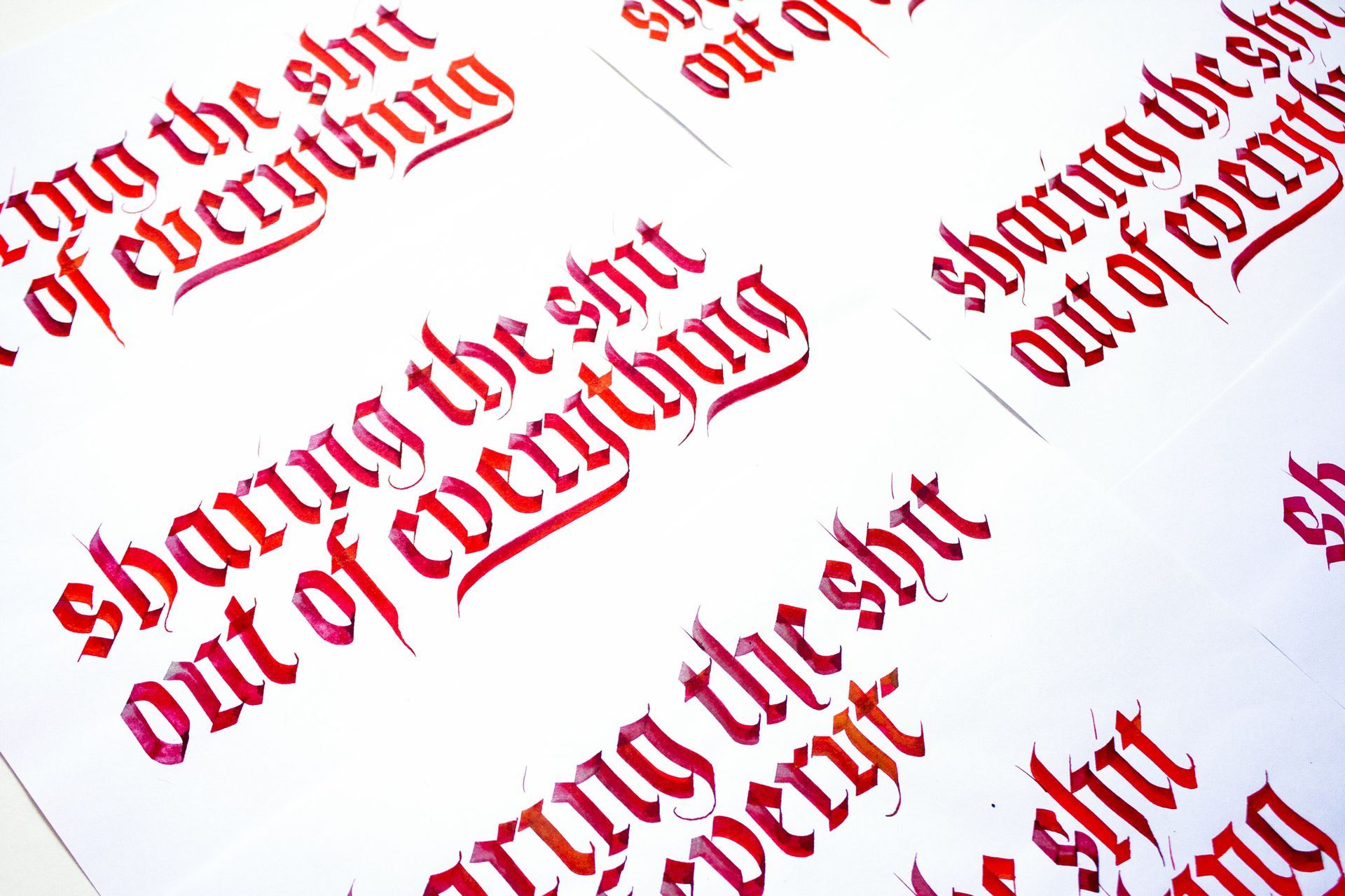 Handwritten calligraphy in red ink on white paper, repeating the phrase