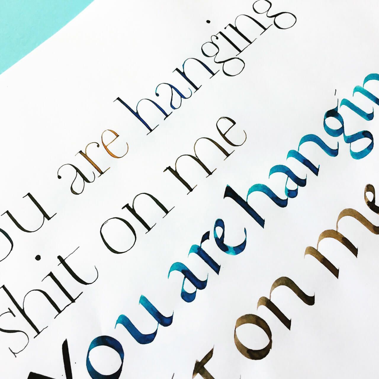 A sheet of paper featuring the repeated, multi-colored foil-stamped text