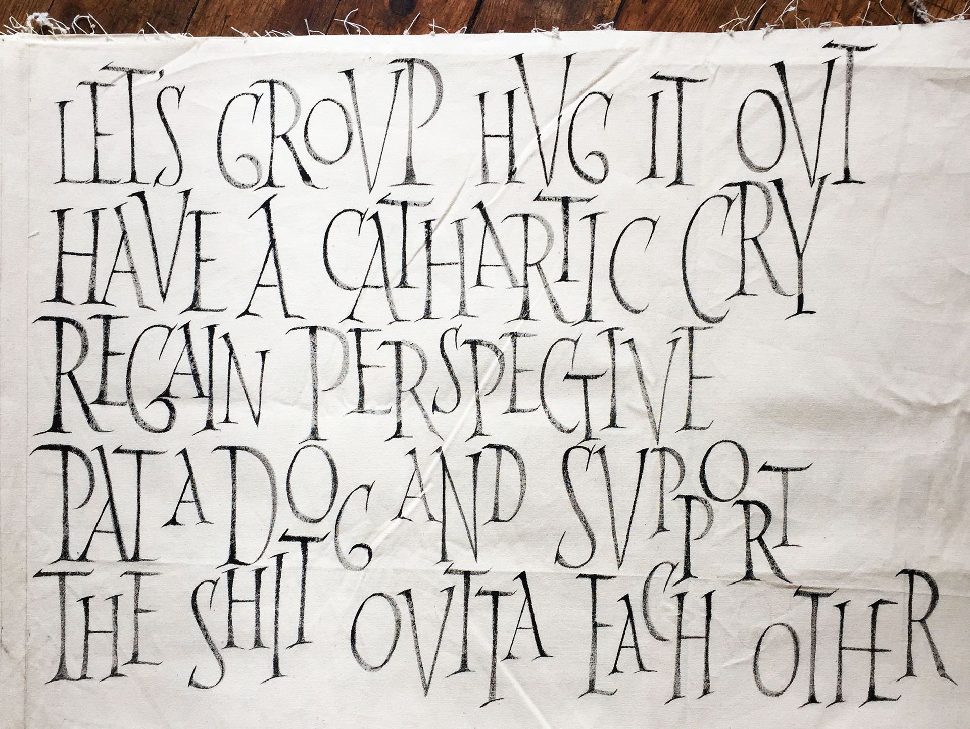 Black handwritten text on a light fabric background: