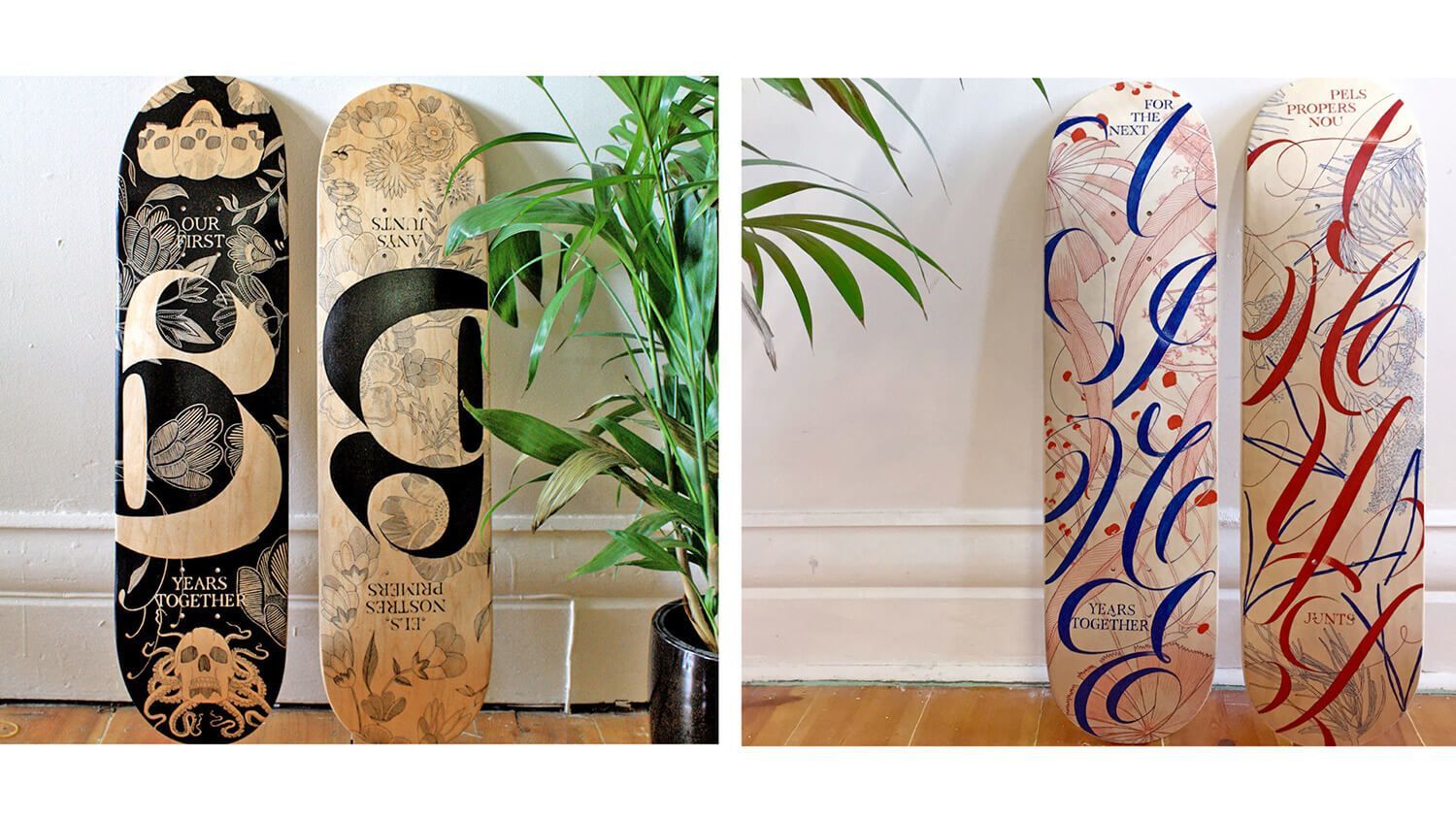 Two decorated skateboards leaning indoors, one black and tan, one white with red and blue swirls.