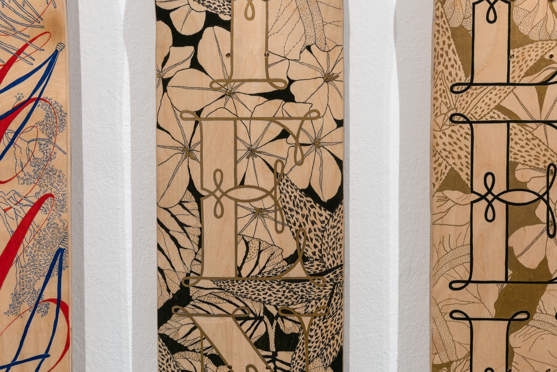 Three vertical panels display decorative typography featuring the letters E and L over intricate, patterned floral designs.