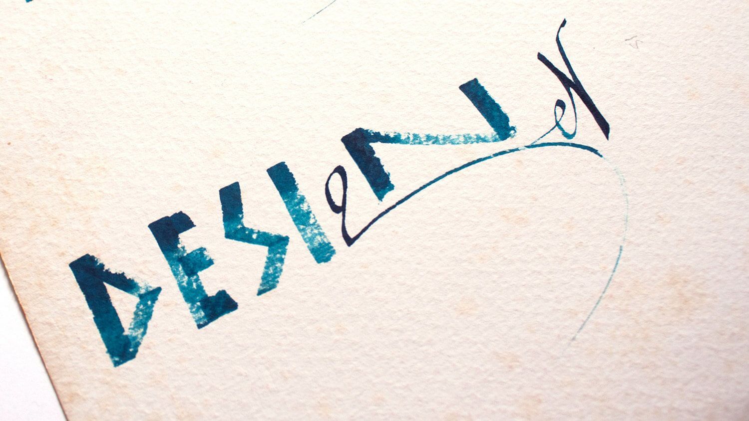 Blue hand-drawn “DESIGN” text with a zigzag line on a light background