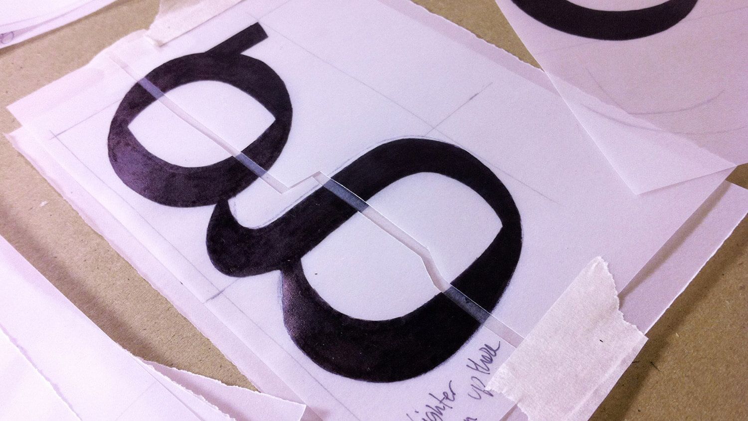 Black eyeglasses on white paper templates with pink trimming sheets around them