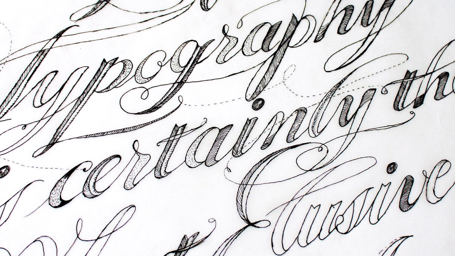 Close-up of elegant cursive handwriting on white paper, showing decorative calligraphy.