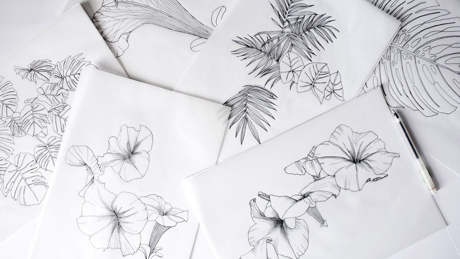 Black-and-white floral line drawings arranged on white sheets and notebooks