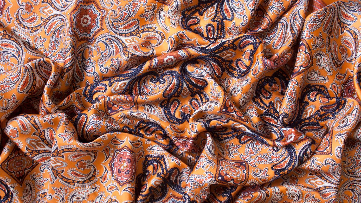 Orange and blue patterned fabric with folds and wrinkles