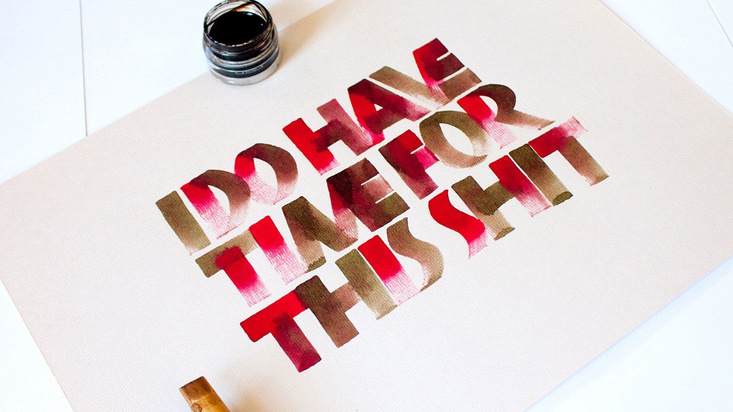 Red 3D “DHA” and “THAT” text on white paper beside a black ink bottle