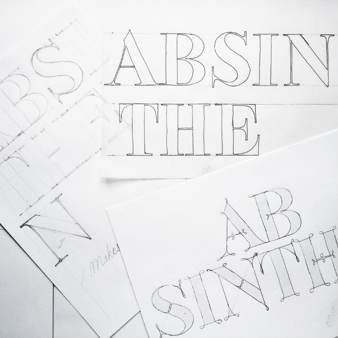 Large stylized serif letters on a white background, overlapping and partially visible, with faint diagonal sketches.