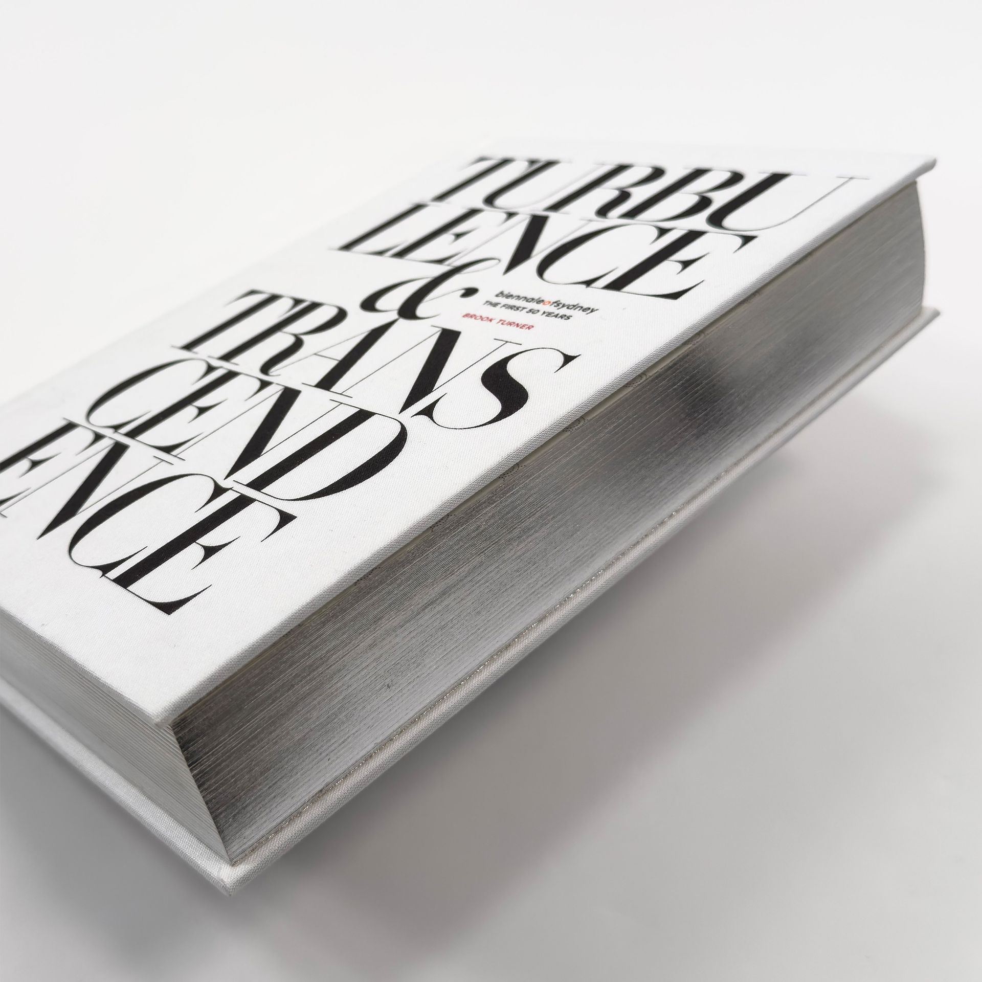 A stack of white magazines with bold black typography on the cover