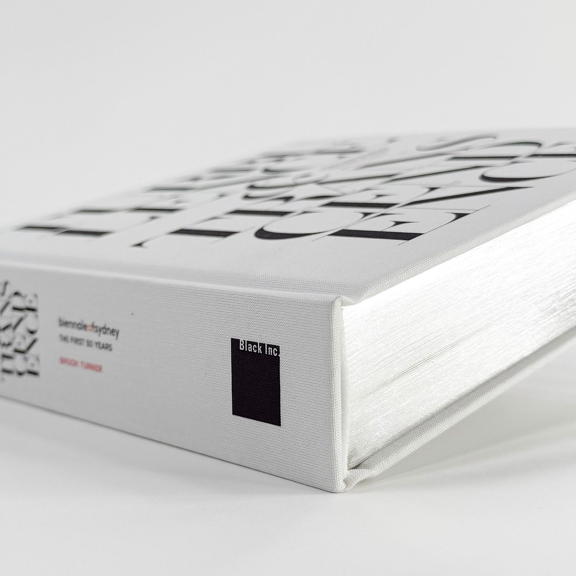 White textured book or box with black lettering, shown in close-up on a plain background