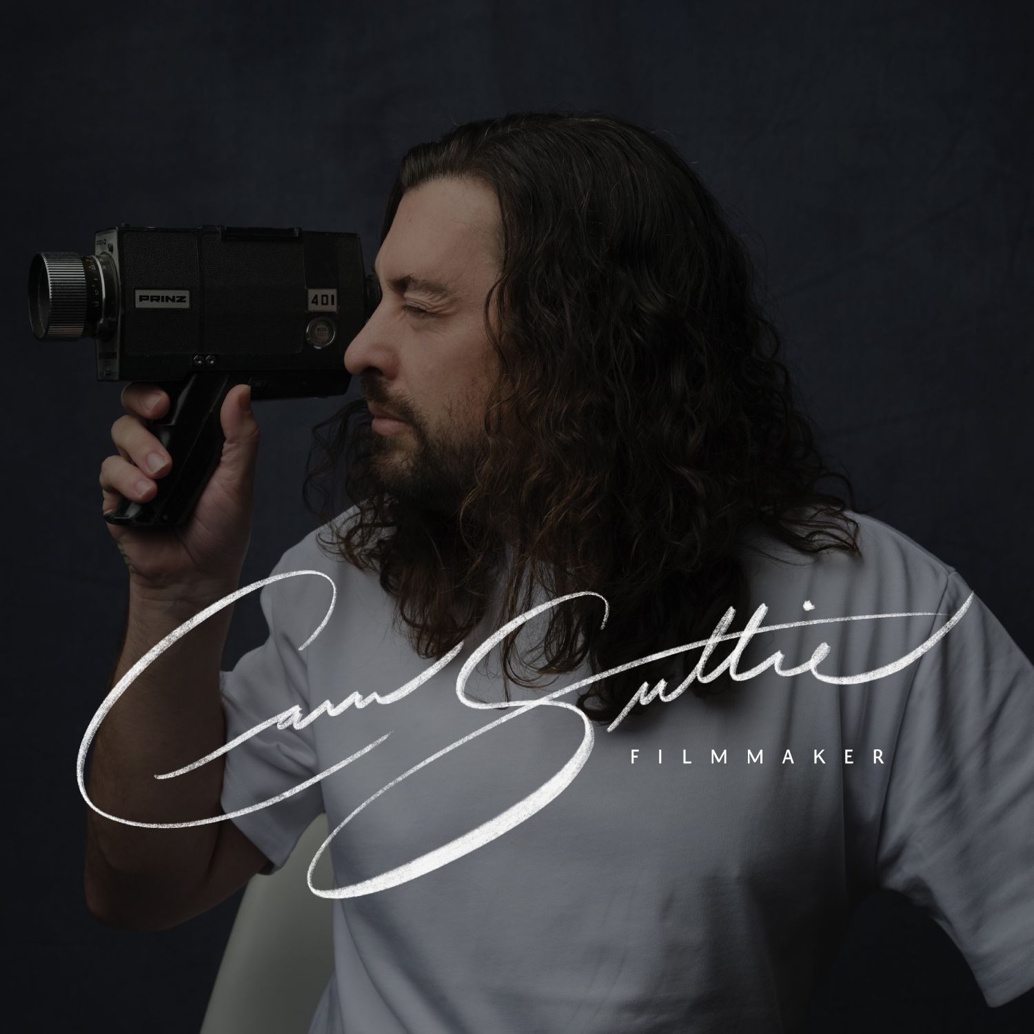 Man holding a vintage camera in profile, with a white signature-style logo on a dark background