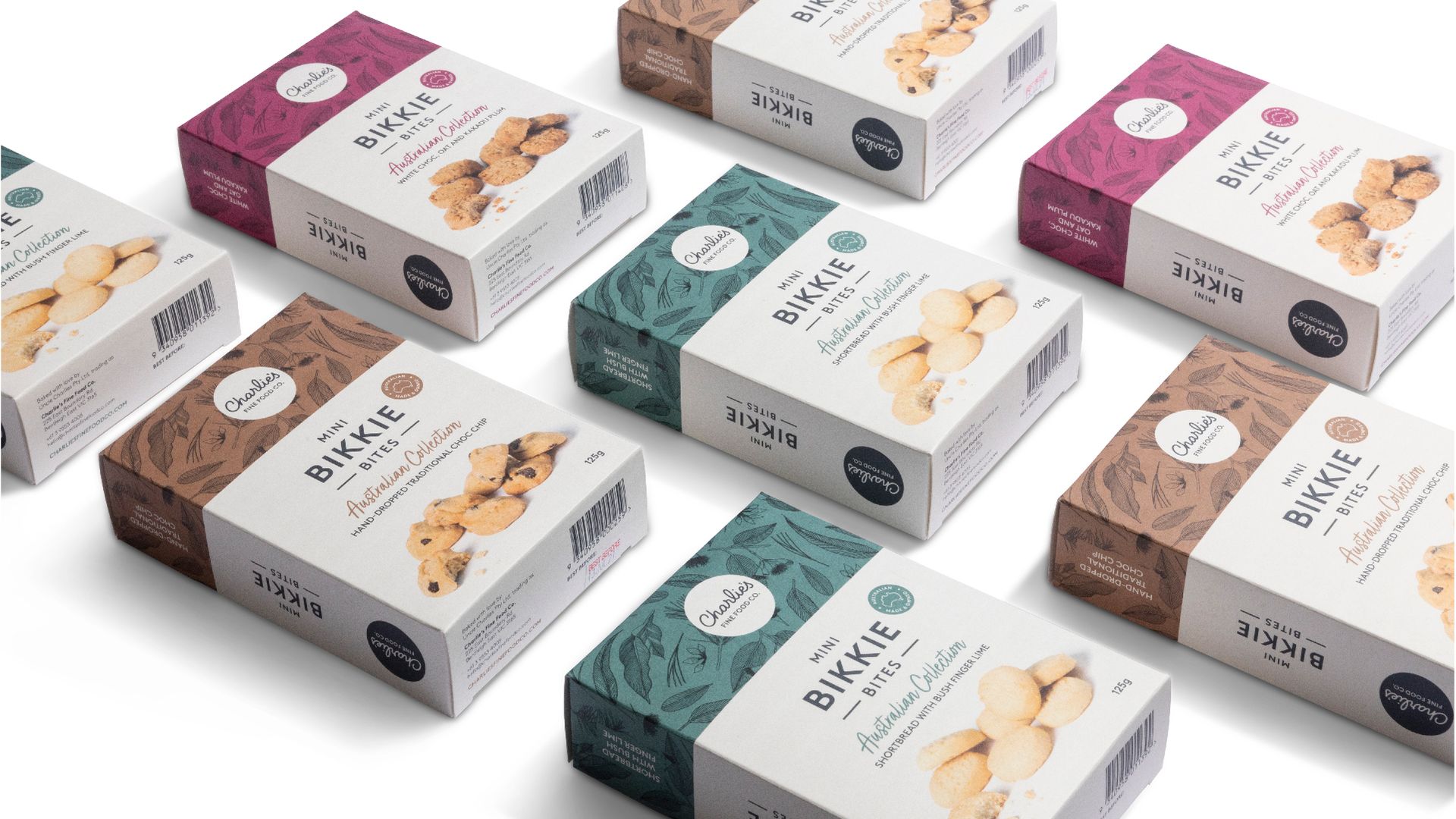Assorted stacked snack boxes with white, brown, green, and magenta packaging on a light background