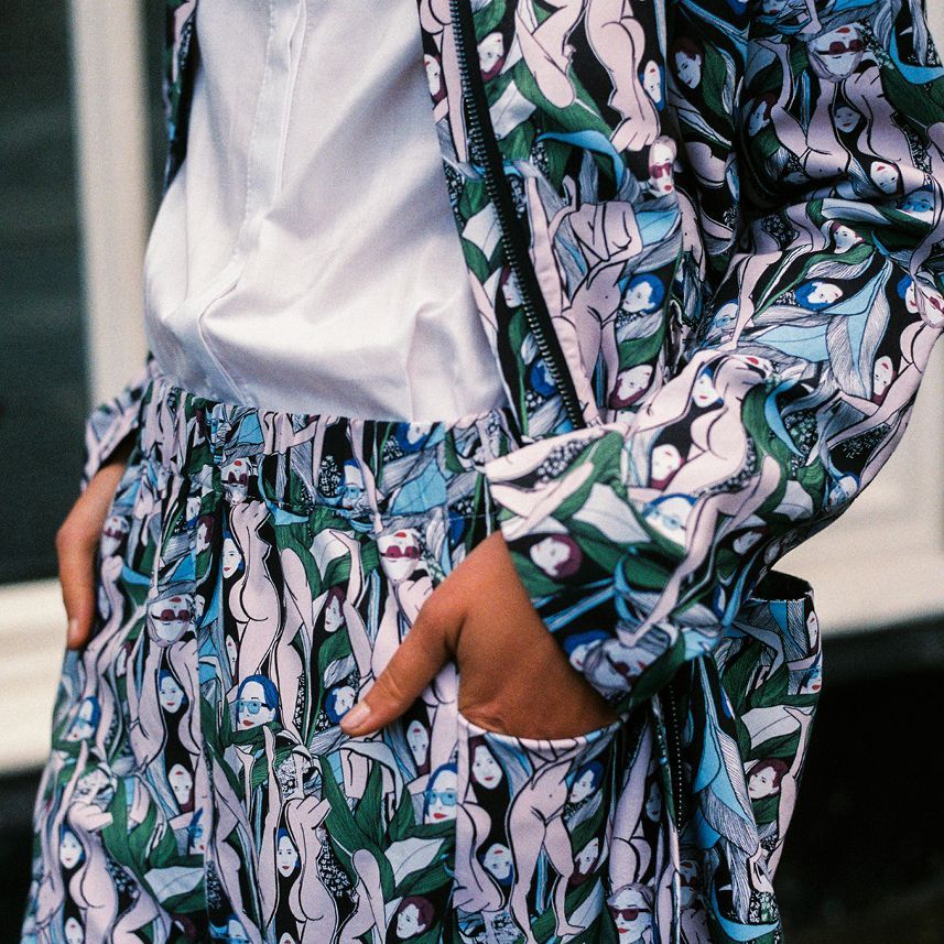 Person wearing a white shirt and floral-patterned jacket with hands in pockets