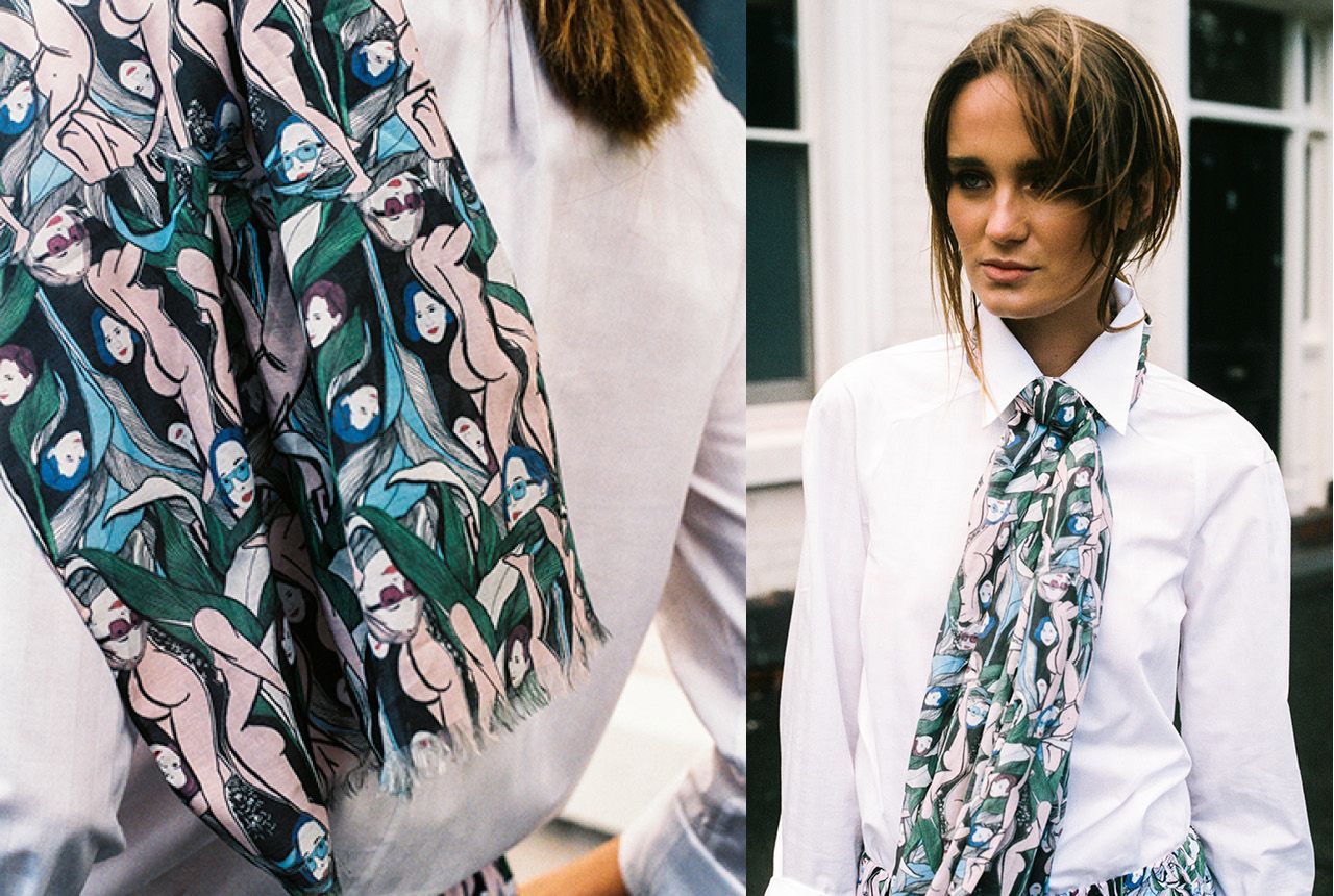 Fashion model in white shirt wearing a patterned teal, pink, and black scarf