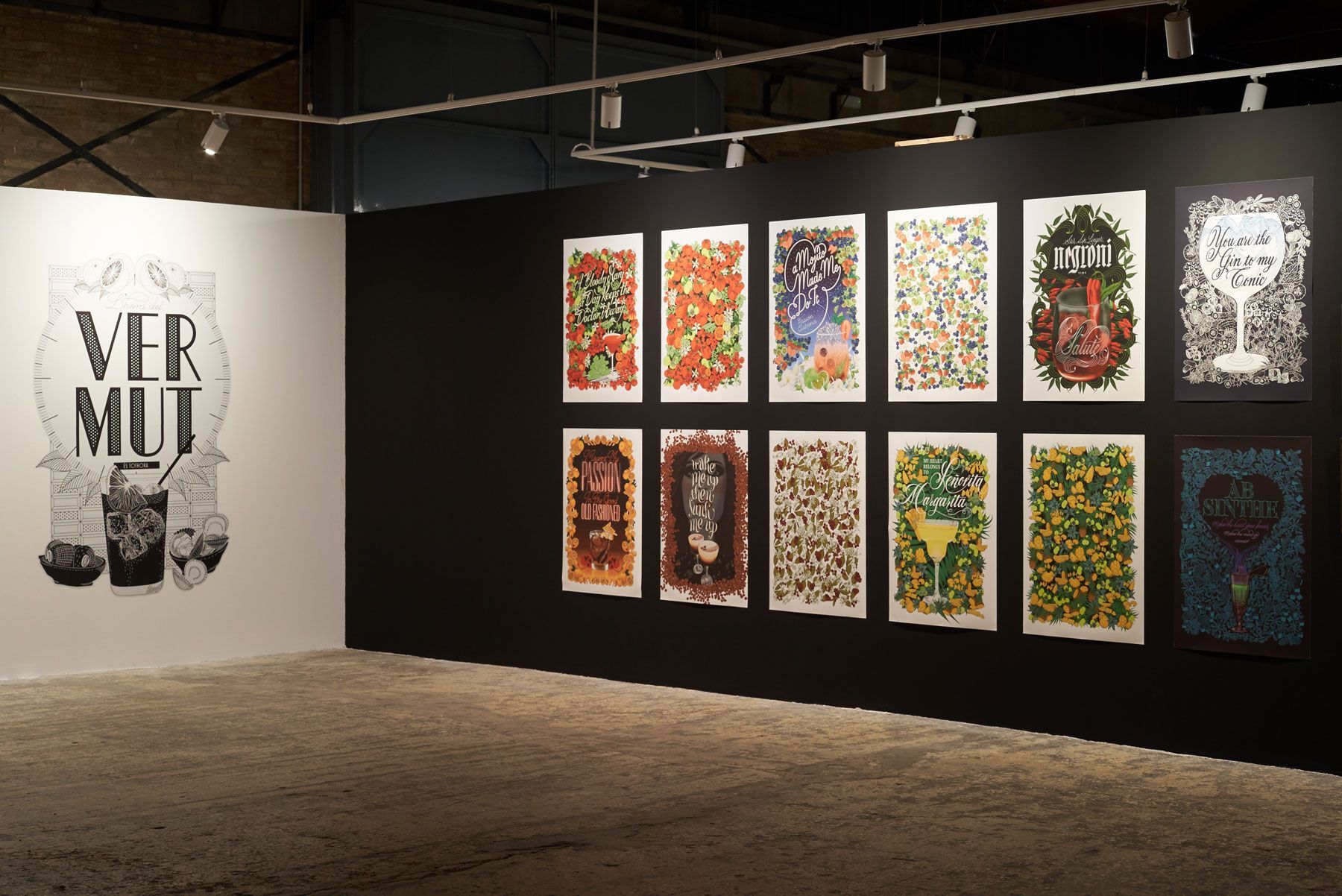 Art gallery wall with a large black-and-white poster and a grid of colorful framed prints.