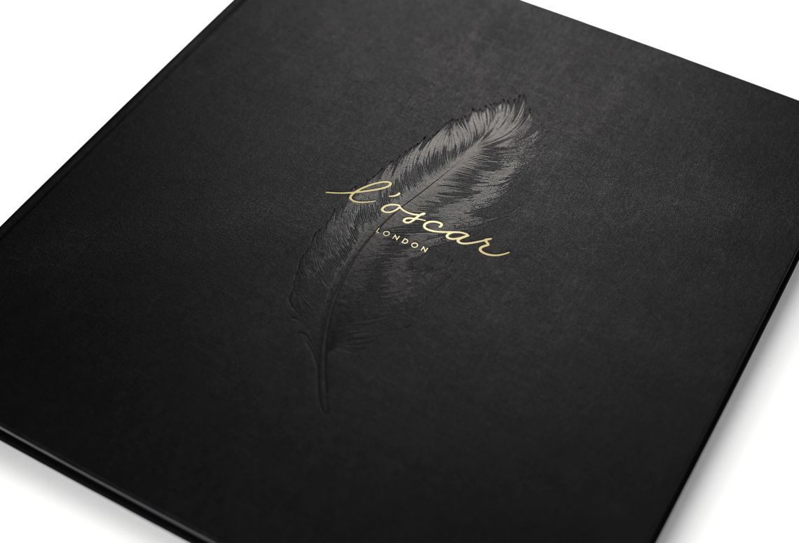 Black box with a feather and gold script logo on the cover, shown at an angle.