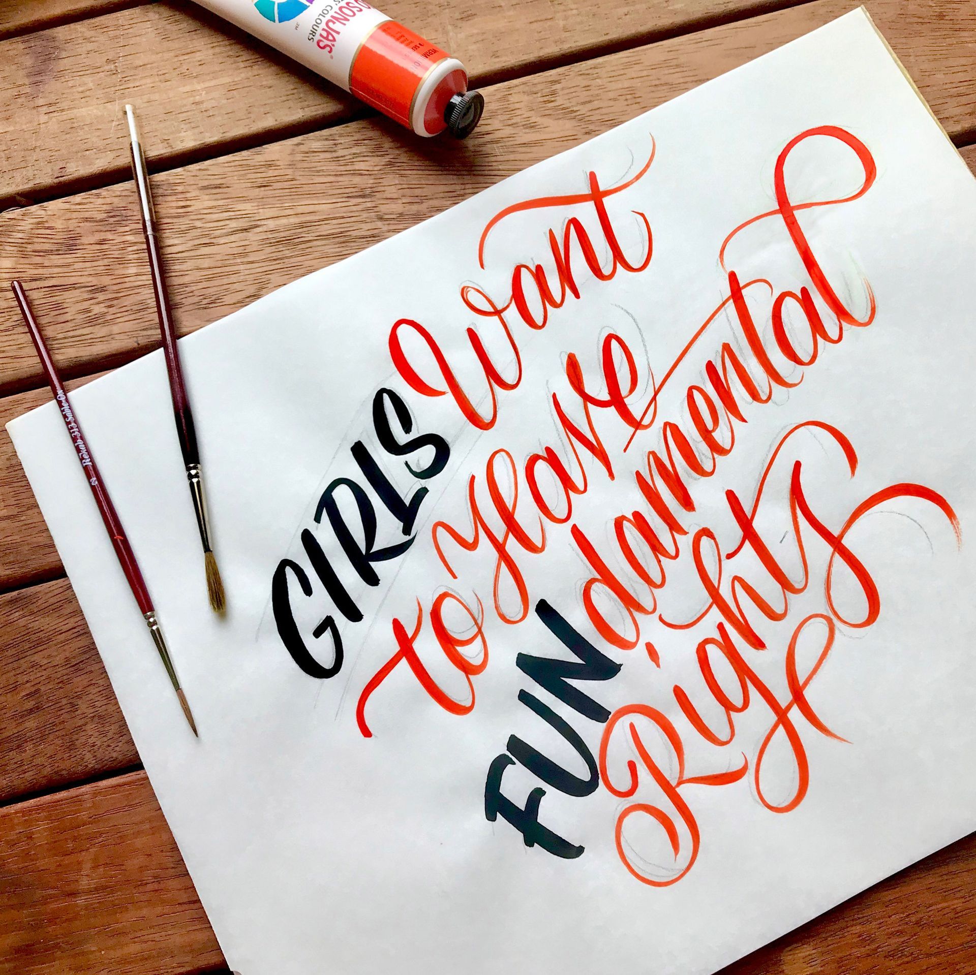 A sunset over the ocean with the cursive white text,