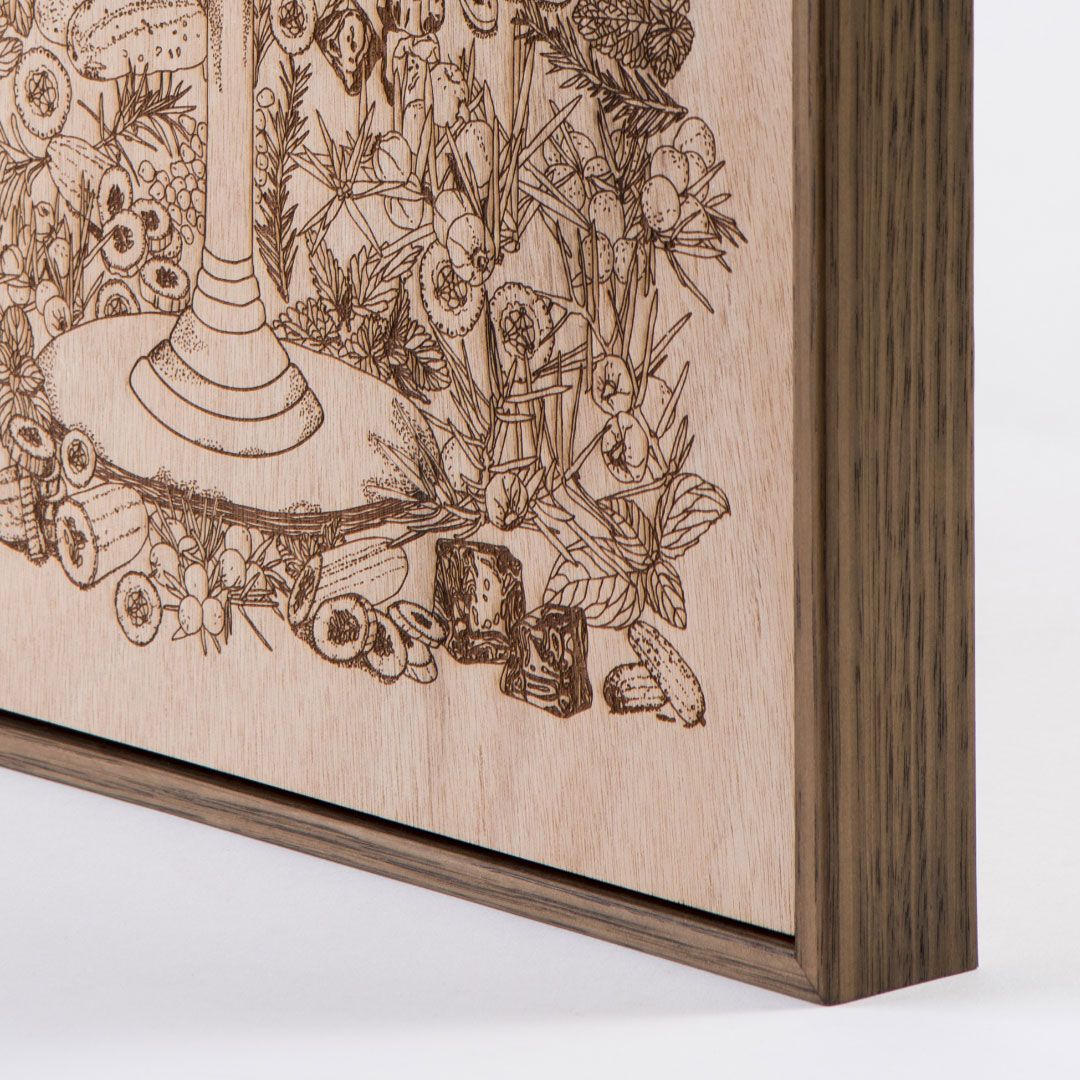 Wooden framed engraving with a detailed botanical and decorative illustration on a light background