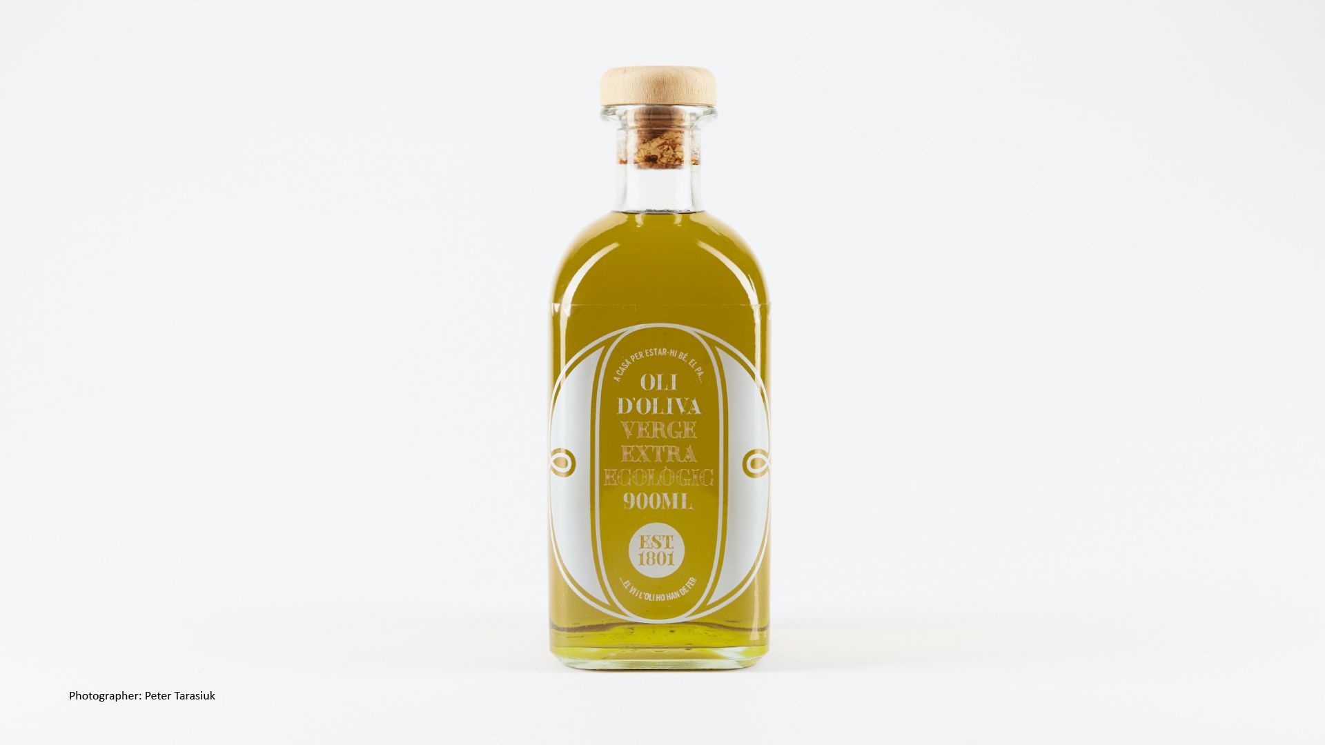 Green Fairy Font. Clear glass bottle of golden liquid with a cork stopper and cream label on a white background