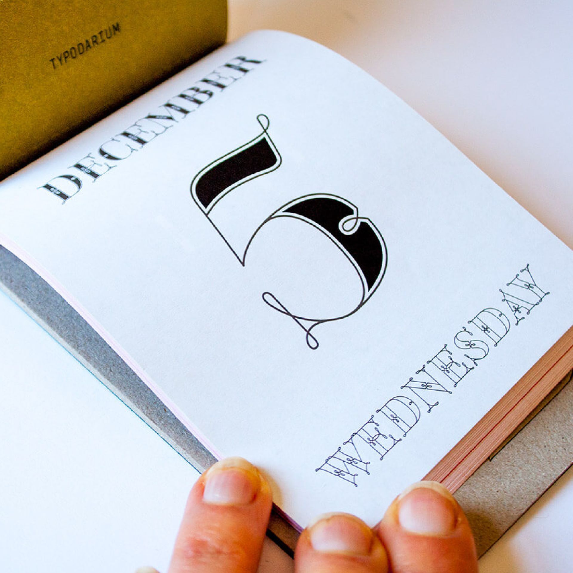 Green Fairy Font. Open book showing a stylized number 5 and the words “DECEMBER” and “WEDNESDAY.”